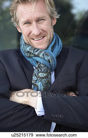 Businessman wearing extravagant scarf leaning against window. View Large Photo Image Stock Photo - Businessman wearing extravagant scarf leaning against window.. Fotosearch