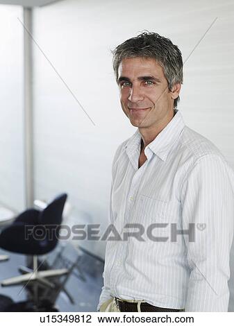 Businessman wearing open neck shirt in office, smiling, portrait View Large Photo Image Stock Image - Businessman wearing open neck shirt in office, smiling, portrait. Fotosearch