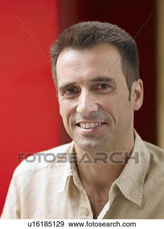 Man standing beside red wall, smiling, close-up, portrait View Large Photo Image Stock Photo - Man standing beside red wall, smiling, close-up, portrait. Fotosearch