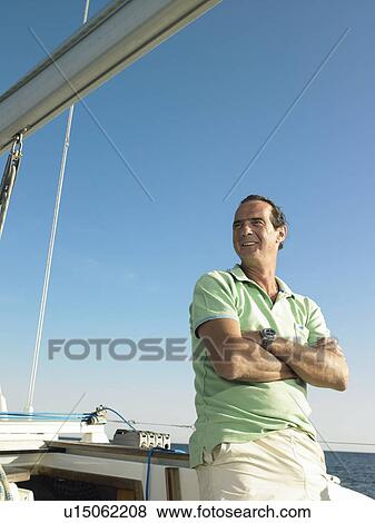 Mature man standing on yacht, smiling View Large Photo Image Stock Photo - Mature man standing on yacht, smiling. Fotosearch