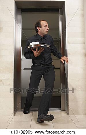 Waiter rushing out of an elevator View Large Photo Image Stock Photography - Waiter rushing out of an elevator. Fotosearch