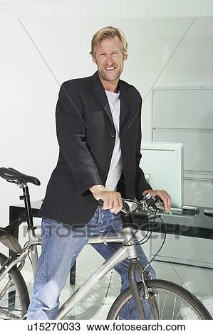 Young businessman in office building with bicycle. View Large Photo Image Stock Image - Young businessman in office building with bicycle.. Fotosearch