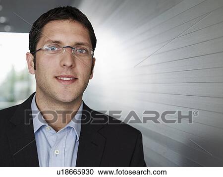Stock Image - Young businessman smiling, close-up, portrait. Fotosearch