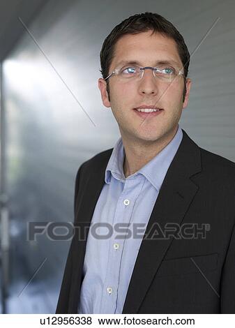 Young businessman wearing spectacles, smiling View Large Photo Image Stock Photo - Young businessman wearing spectacles, smiling. Fotosearch