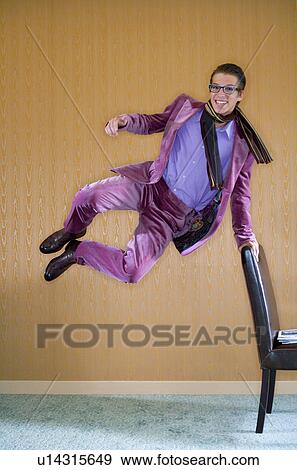Stock Photo - Young man in purple suit jumps for joy.. Fotosearch