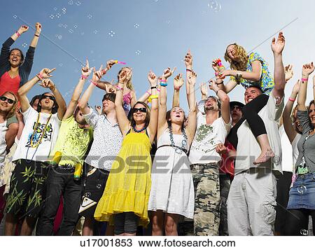 Crowd of young people cheering and waving View Large Photo Image Stock Image - Crowd of young people cheering and waving. Fotosearch
