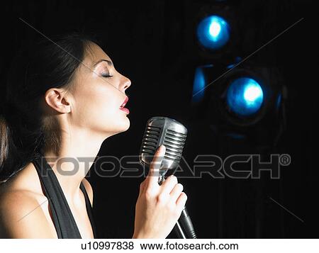 Stock Photo - Female singing into microphone.. Fotosearch