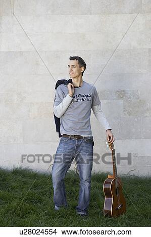 Man standing with a guitar. View Large Photo Image Picture - Man standing with a guitar.. Fotosearch