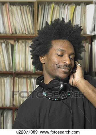 Man using headphones in music shop, eyes closed, smiling View Large Photo Image Stock Photo - Man using headphones in music shop, eyes closed, smiling. Fotosearch