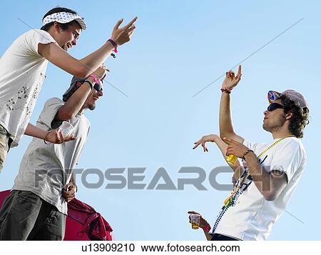 Stock Image - Three males dancing outside. Fotosearch
