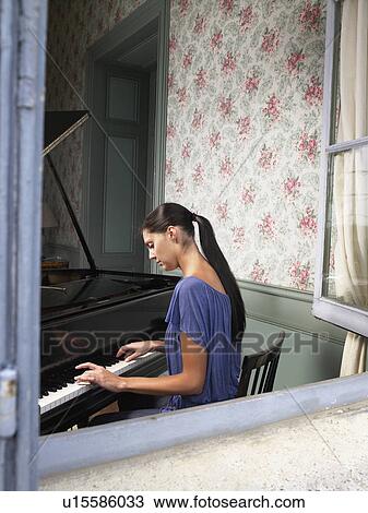 Stock Image - Woman playing piano.. Fotosearch