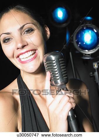 Woman smiling and holding microphone. View Large Photo Image Stock Photo - Woman smiling and holding microphone.. Fotosearch