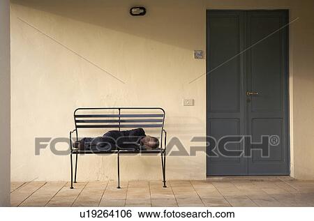 Boy (4-6) lying on bench outdoors View Large Photo Image Stock Photograph - Boy (4-6) lying on bench outdoors. Fotosearch
