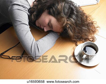 Businesswoman resting head on desk by coffee cup, eyes closed View Large Photo Image Stock Photo - Businesswoman resting head on desk by coffee cup, eyes closed. Fotosearch