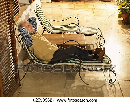 Senior man lying on sun lounger on terrace, eyes closed View Large Photo Image Stock Photo - Senior man lying on sun lounger on terrace, eyes closed. Fotosearch