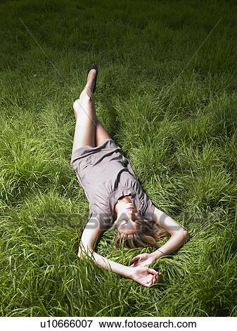 Woman relaxing in a green field. View Large Photo Image Stock Photo - Woman relaxing in a green field.. Fotosearch