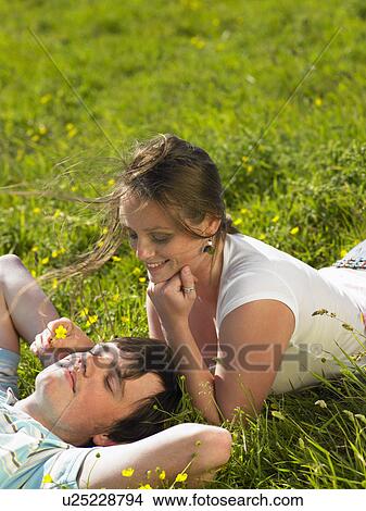 You couple lying in the grass. View Large Photo Image Picture - You couple lying in the grass.. Fotosearch