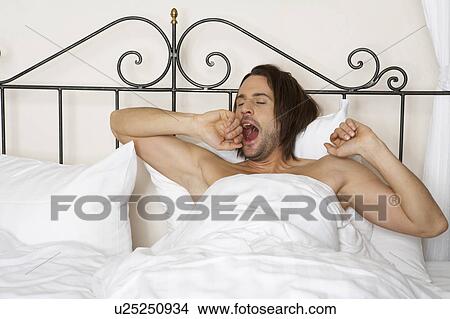 young man yawning in bed View Large Photo Image Picture - young man yawning in bed. Fotosearch
