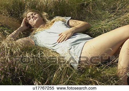 Young woman lying in long grass. View Large Photo Image Stock Photography - Young woman lying in long grass.. Fotosearch
