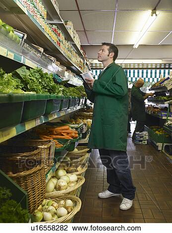 Grocer checking shelves View Large Photo Image Stock Image - Grocer checking shelves. Fotosearch