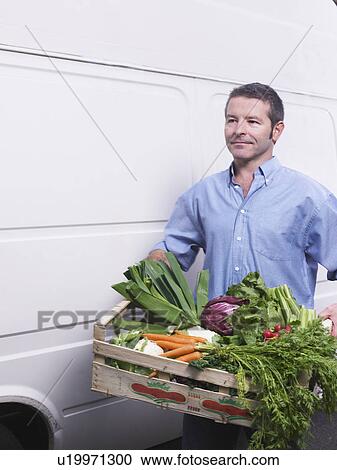Man carrying crate of vegetables from van View Large Photo Image Stock Image - Man carrying crate of vegetables from van. Fotosearch
