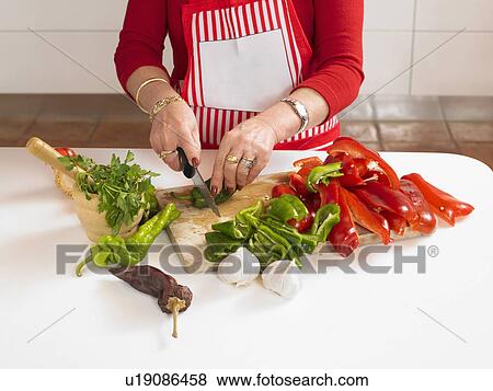 Mature woman chopping vegetables in kitchen, mid section View Large Photo Image Stock Photo - Mature woman chopping vegetables in kitchen, mid section. Fotosearch