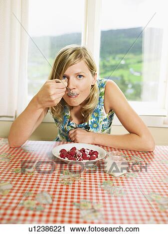 Woman eating bowl of raspberries with cream at table. View Large Photo Image Stock Image - Woman eating bowl of raspberries with cream at table.. Fotosearch