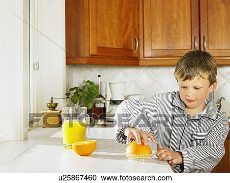 Young boy making orange juice in kitchen. View Large Photo Image Stock Image - Young boy making orange juice in kitchen.. Fotosearch