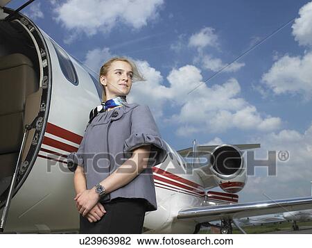 Flight attendant beside private jet. View Large Photo Image Stock Image - Flight attendant beside private jet.. Fotosearch