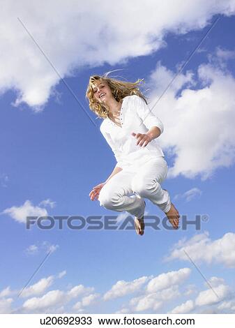 Stock Image - Girl jumping in the air.. Fotosearch