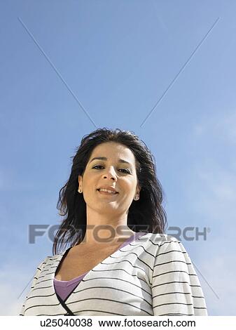 Stock Photo - Low angle portrait of woman against sky, Alicante, Spain,. Fotosearch