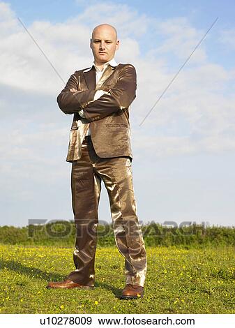 Man in gold suit standing in field. View Large Photo Image Stock Photo - Man in gold suit standing in field.. Fotosearch