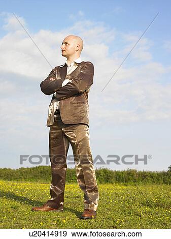 Man in gold suit standing in field. View Large Photo Image Stock Photo - Man in gold suit standing in field.. Fotosearch
