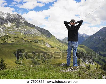 Stock Photograph - Man looking at mountains.. Fotosearch