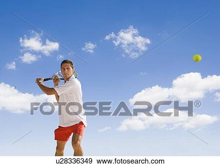 Man playing tennis against blue sky. View Large Photo Image Stock Photo - Man playing tennis against blue sky.. Fotosearch
