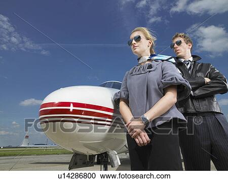 Pilot and flight attendant standing in front of private jet. View Large Photo Image Stock Image - Pilot and flight attendant standing in front of private jet.. Fotosearch