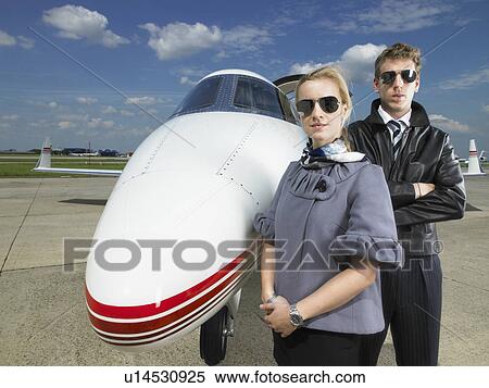 Pilot and flight attendant standing in front of private jet. View Large Photo Image Stock Photography - Pilot and flight attendant standing in front of private jet.. Fotosearch