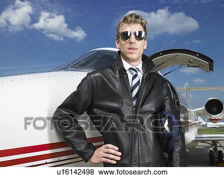 Pilot standing beside private jet. View Large Photo Image Stock Photo - Pilot standing beside private jet.. Fotosearch