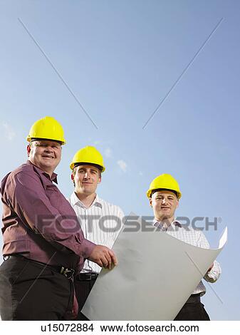 Picture - Three surveyors on a field.. Fotosearch