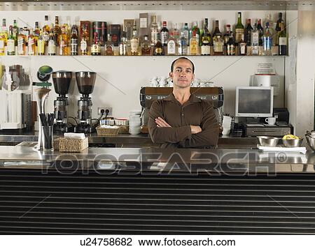 Barista with arms folded standing behind the counter in café. Alicante, Spain. View Large Photo Image Stock Image - Barista with arms folded standing behind the counter in café. Alicante, Spain.. Fotosearch
