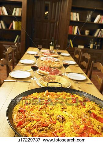 Stock Photo - Large dish of seafood paella on dining table. Fotosearch