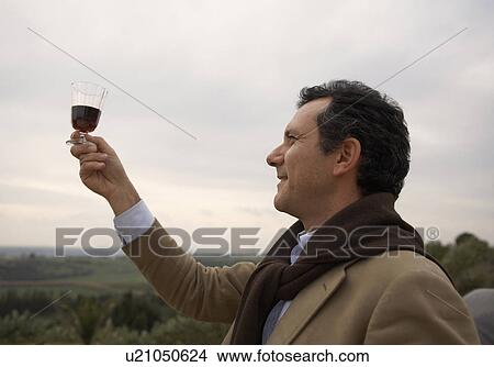 Man looking at wine outdoors View Large Photo Image Picture - Man looking at wine outdoors. Fotosearch