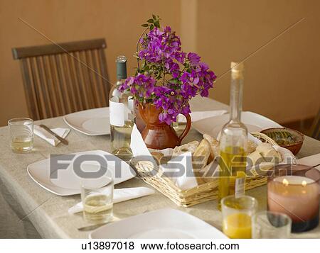 Place settings and purple flowers in vase on dining table (still life) View Large Photo Image Stock Photo - Place settings and purple flowers in vase on dining table (still life). Fotosearch