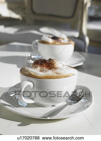 Two cappuccinos on table, close-up View Large Photo Image Stock Photo - Two cappuccinos on table, close-up. Fotosearch