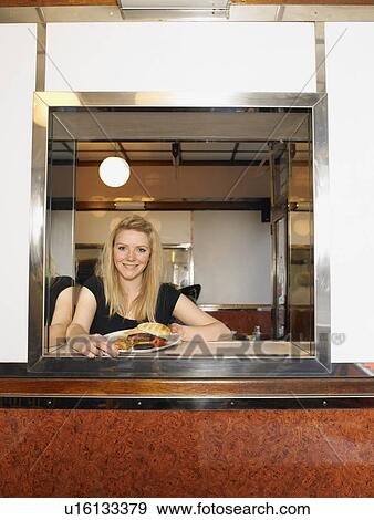 Waitress holding plate of fried food at cafe counter, smiling View Large Photo Image Stock Photo - Waitress holding plate of fried food at cafe counter, smiling. Fotosearch