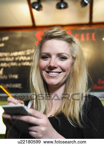 Young waitress holding notepad in cafe, smiling, portrait View Large Photo Image Stock Photo - Young waitress holding notepad in cafe, smiling, portrait. Fotosearch