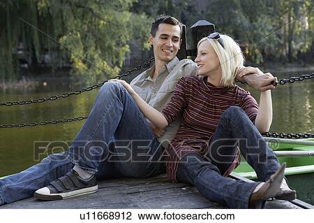 Couple on a dock smiling and relaxing. View Large Photo Image Stock Image - Couple on a dock smiling and relaxing.. Fotosearch