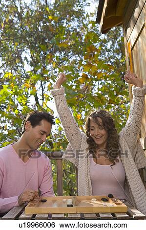 Couple playing backgammon outdoors smiling. View Large Photo Image Stock Photograph - Couple playing backgammon outdoors smiling.. Fotosearch