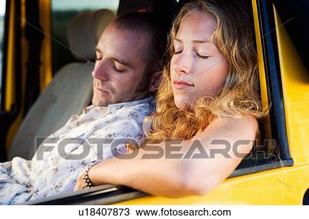 Stock Image - Couple sleeping in a van.. Fotosearch