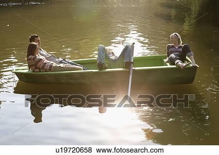 Four friends in a rowboat smiling and relaxing. View Large Photo Image Stock Photo - Four friends in a rowboat smiling and relaxing.. Fotosearch